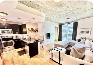 Ein modernes Apartment mit Küche, Essbereich und Wohnzimmer.