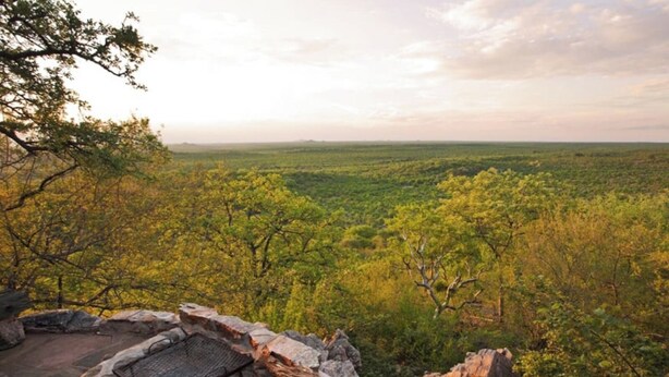 Un hogar de piedra rodeado de un paisaje natural.
