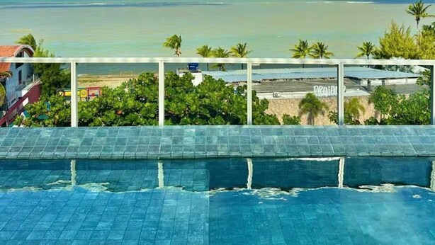Une piscine avec vue sur l’océan et la plage.