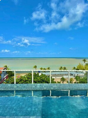 A swimming pool with a view of the ocean and beach. - Way Bossa · Beautiful Caribessa Flat with balcony (João Pessoa)