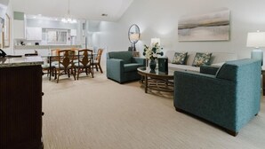 A spacious living room with a sofa, a coffee table, and a dining area with chairs and a table. - 3-bedroom 4 Beds condo in Shipyard Plantation, Hilton Head Island w/beach access (Hilton Head Island)