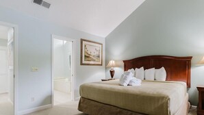 A hotel room with a large bed, a nightstand, a lamp, and a painting on the wall. - 3-bedroom 4 Beds condo in Shipyard Plantation, Hilton Head Island w/beach access (Hilton Head Island)