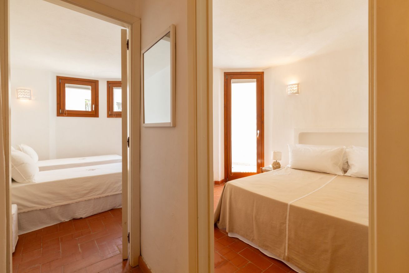 A room with a bed, a window, and a door.