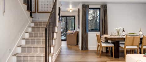 Ein modernes Interieur mit Treppe, Essbereich und Blick ins Freie.