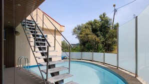 A swimming pool with a staircase leading to a building, surrounded by a fence and trees. - Apartment 'Casa Do Lagar' with Lake View, Wi-Fi and Air Conditioning (Geres)