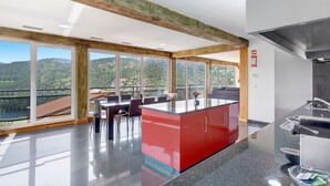 A modern kitchen with large windows, a central island, and a view of the outdoors. - Apartment 'Casa Do Lagar' with Lake View, Wi-Fi and Air Conditioning (Geres)