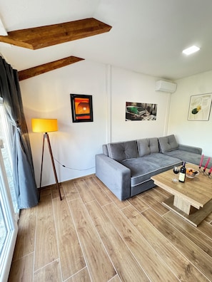 A modern living room with a grey sofa, wooden coffee table, and a standing lamp. - Authentic MNE stone villa with renovated apartments - 10 min to Lake Skadar (Virpazar)