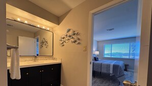 Un baño con tocador, espejo y perchero para toallas.