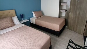 Ett hotellrum med två sängar, en garderob, ett skrivbord och en stol.