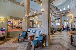 Un vestíbulo con mostrador de recepción, zona de estar y vistas al restaurante.