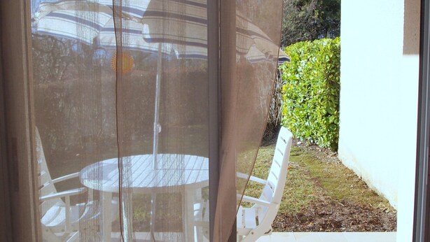 A room with a sliding glass door leading to an outdoor patio area. - Apartment “Soleil D'Oc 5” with Private Terrace and Wi-Fi (Cazaubon)