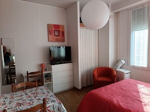 A bedroom with a bed, a desk, a chair, a television, a wardrobe, and a window with curtains. - Apartment “Sauges 16” with Wi-Fi (Cazaubon)