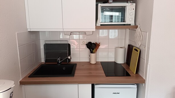 A compact kitchen with a microwave, sink, and a small refrigerator. - Apartment “Sauges 16” with Wi-Fi (Cazaubon)