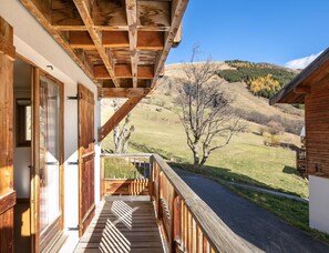 A wooden balcony with a view of a hilly landscape. - Comfortable Apartment With Pool Access (Saint-Sorlin-d'Arves)