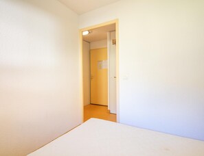 Ein schmaler Flur mit einer Tür zu einem anderen Raum.