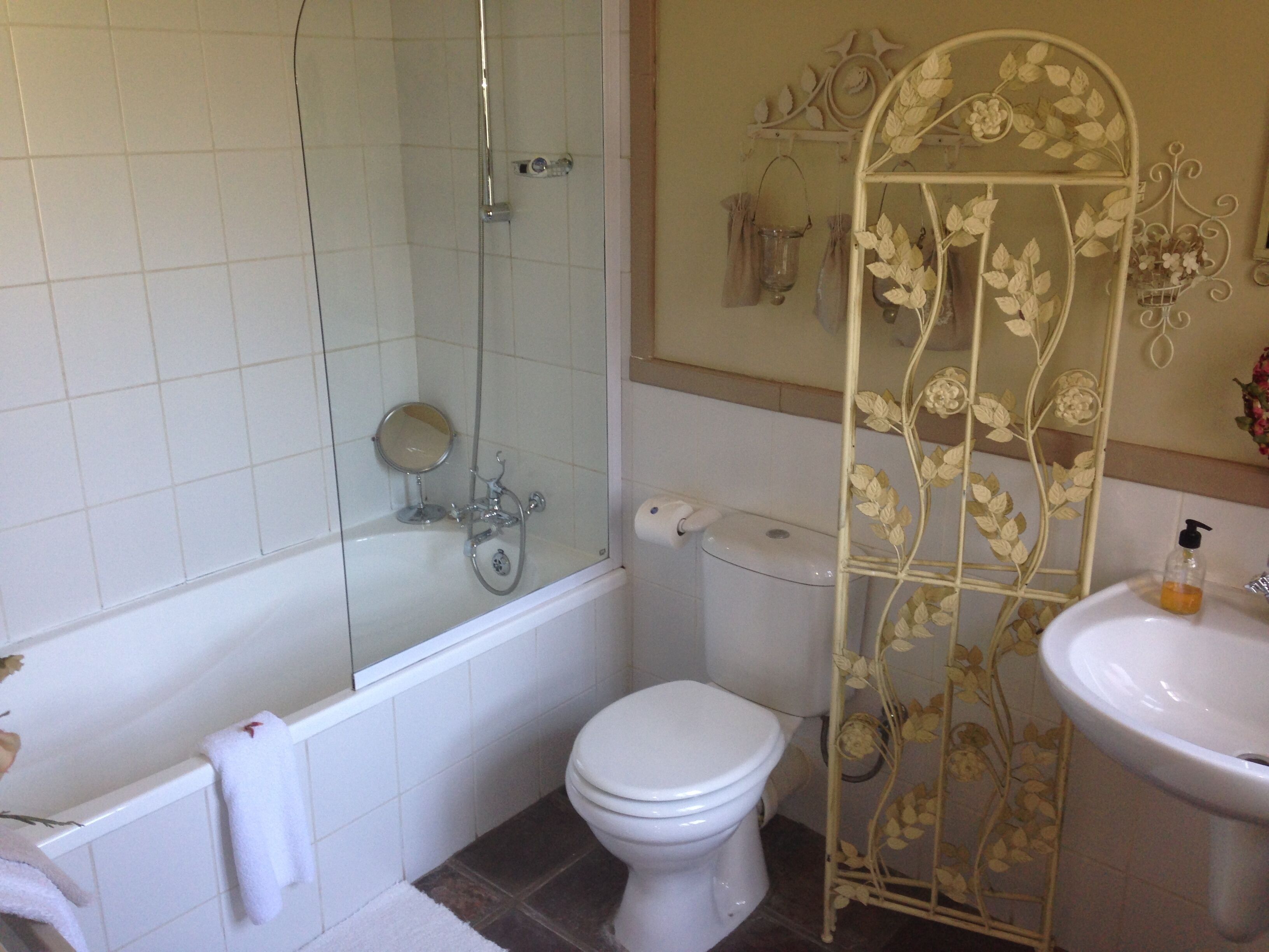 Et badeværelse med badekar, toilet og håndvask.