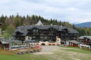 A multi-story hotel with balconies, a ski lift, and a mountainous backdrop. - Alpine Retreat for Four Guests (Morillon)