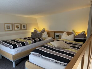 A double room with two single beds, each with striped bedding and pillows. - Vacation apartment Krampe (Borkum)