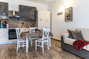 Un espacio habitable compacto con kitchenette, comedor y sofá.