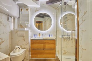 A modern bathroom with a marble vanity, a toilet, and a shower area. - Apartement Saint Germain des Pres (Paris)