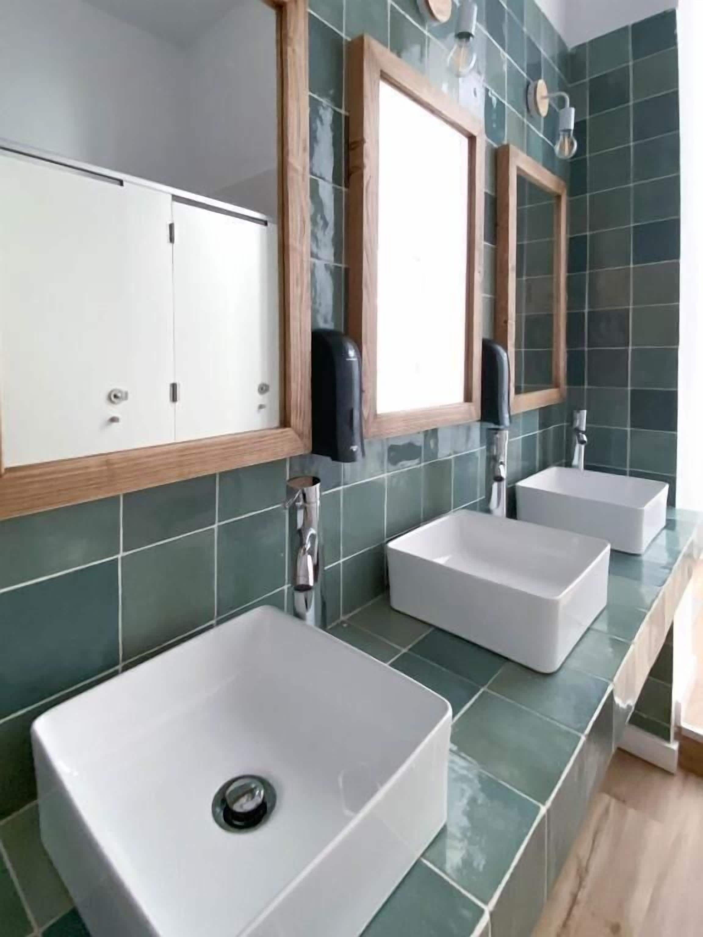 Un baño con dos lavamanos, un espejo y un perchero para toallas.