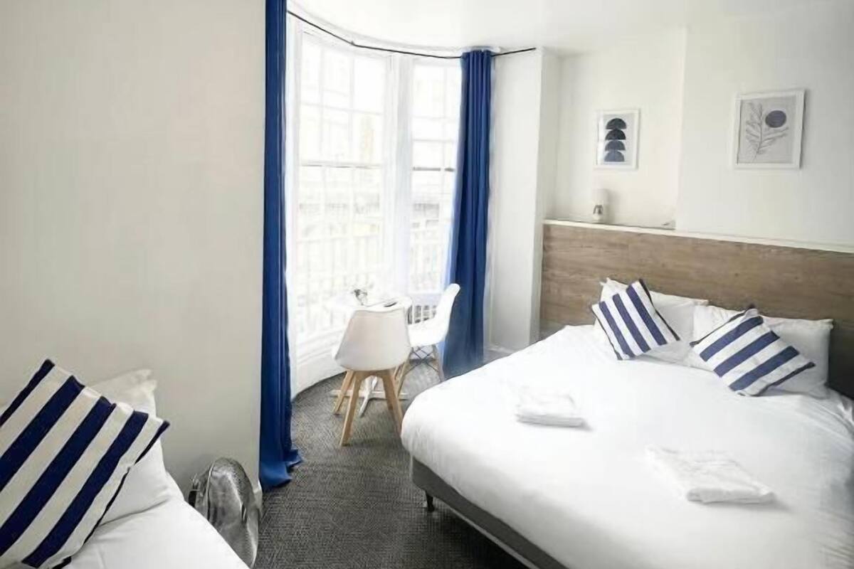 Une chambre d’hôtel avec un lit, un bureau et une chaise.