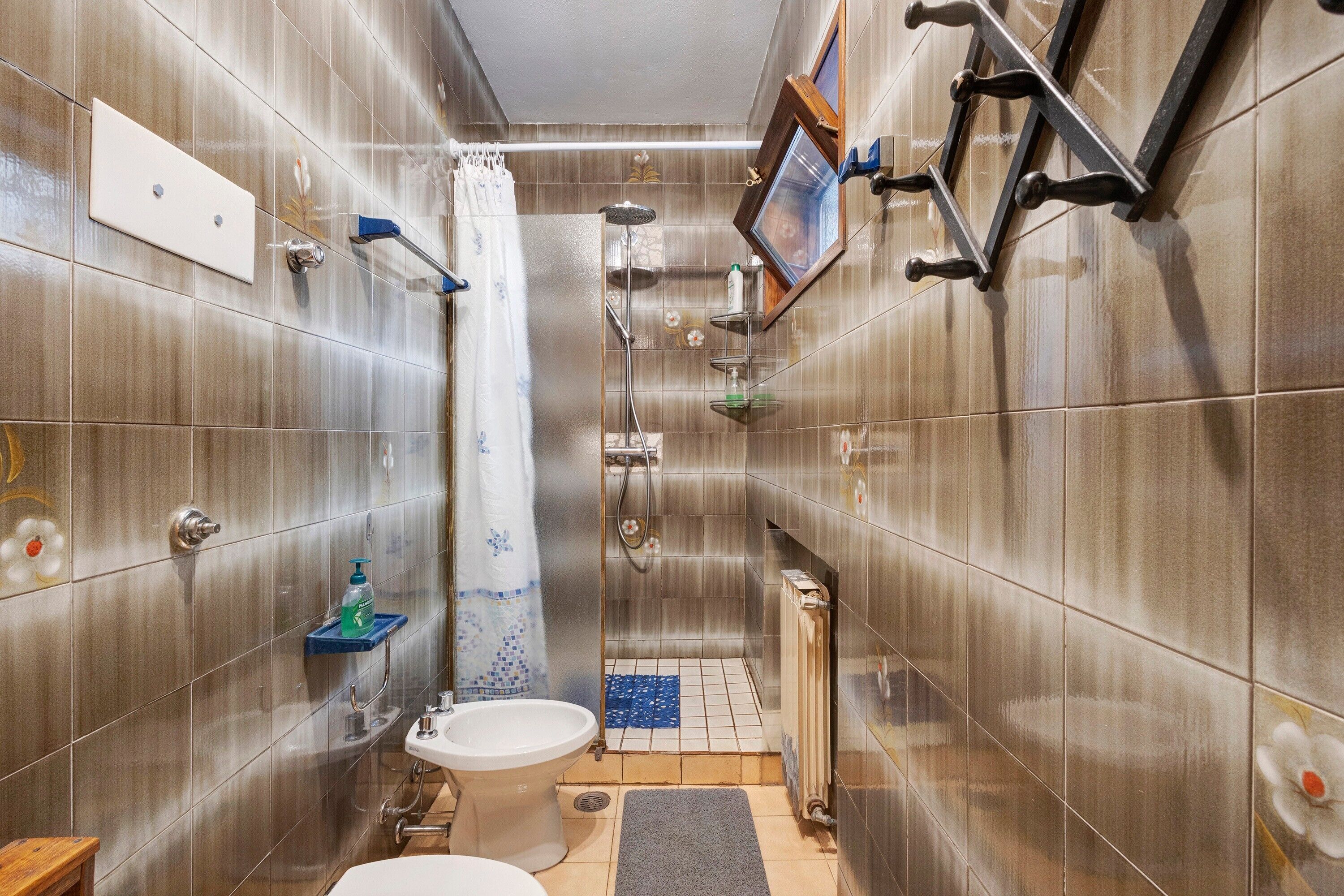 Ein kleines Badezimmer mit Dusche, Toilette und Waschbecken.