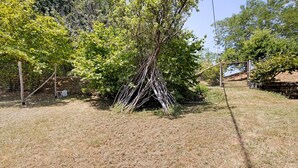 Ein trockenes Grasfeld mit einem Baum und einem Zaun.