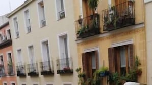 A row of multi-story buildings with balconies, a street below, and a pedestrian walkway. - Hostal Andrea (Madrid)