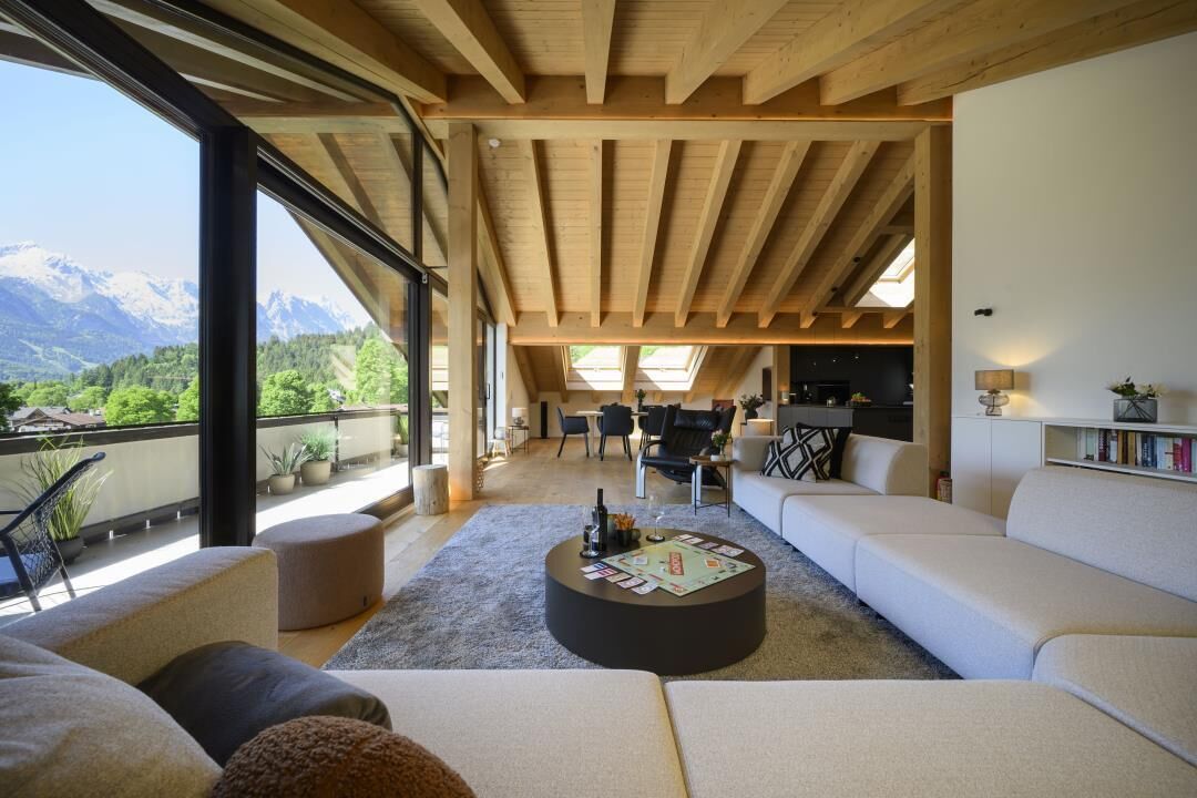 Ein großzügiger Wohnbereich mit hoher Decke, einem runden Couchtisch und einer Couch.