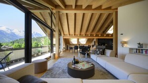 A spacious living area with a high ceiling, a round coffee table, and a sofa. - Alpine Loft Marianne über Garmisch-Partenkirchen (Garmisch-Partenkirchen)