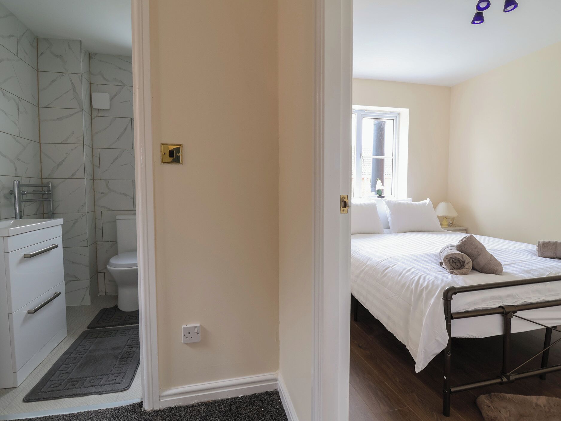 Une chambre d’hôtel avec une salle de bain, un lit et une fenêtre.