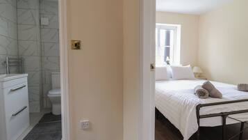 Une chambre d’hôtel avec une salle de bain, un lit et une fenêtre.