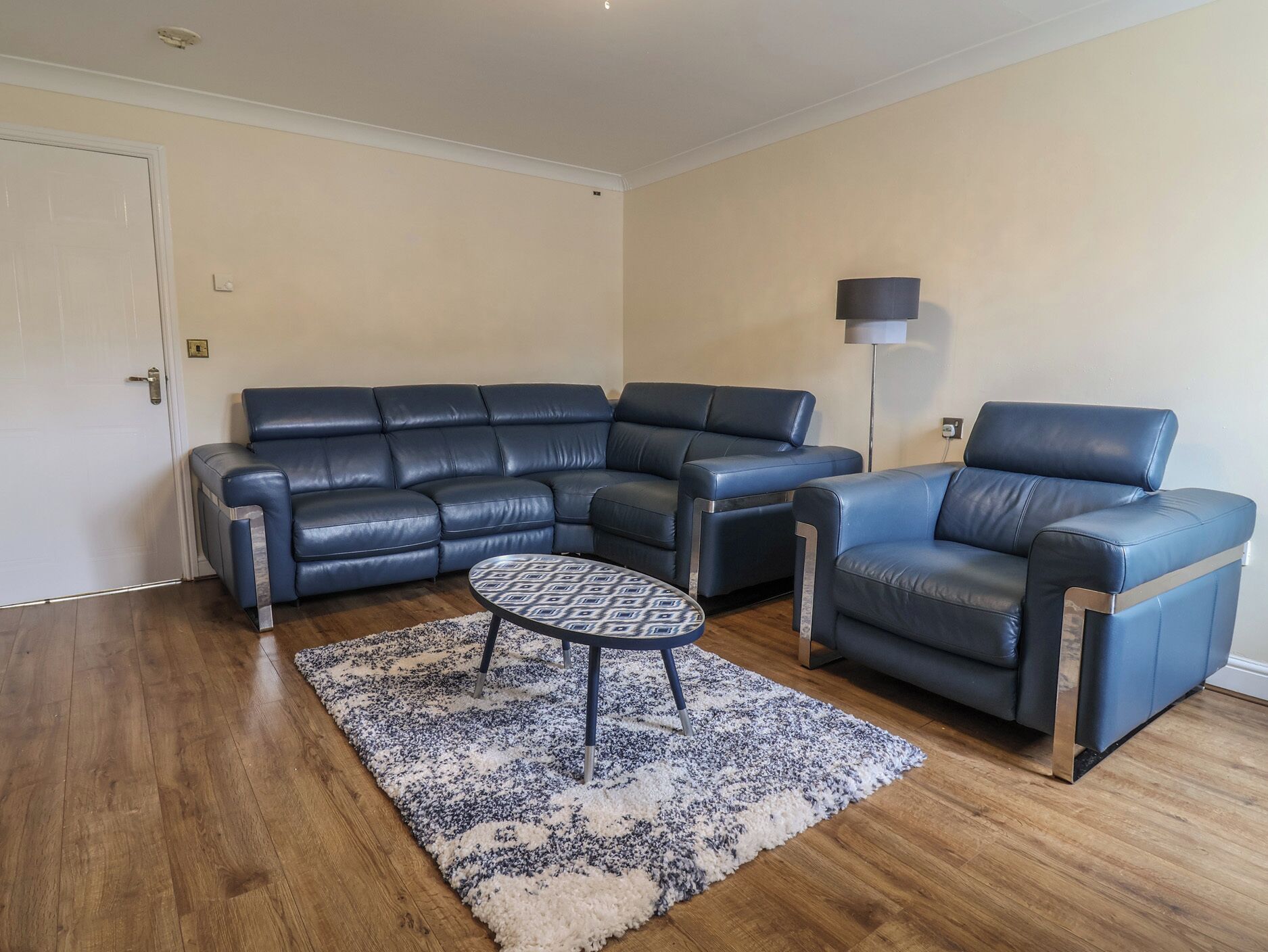 Una sala de estar con un sofá modular, un sillón individual y una mesa de centro.