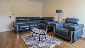 Una sala de estar con un sofá modular, un sillón individual y una mesa de centro.