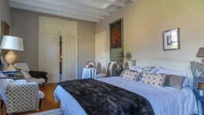 A bedroom with a large bed, a chair, a table, and a mirror. - Traditional house in the heart of Trensacq forest (Trensacq)