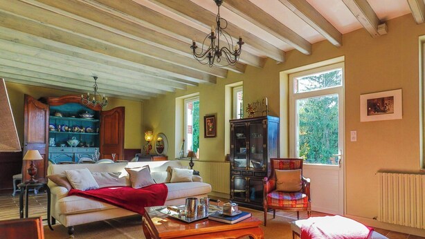 A cozy living room with a sofa, armchair, and coffee table, wooden ceiling beams, and a chandelier. - Traditional house in the heart of Trensacq forest (Trensacq)