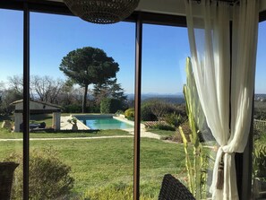 A pool with a pergola, a large tree, and a view of distant mountains. - Provencal villa with pool and panoramic views (La Gaude)