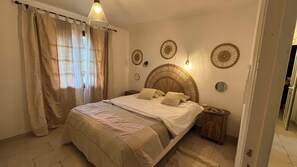 A bedroom with a bed, curtains, a bedside table, wall decor, and a hanging light fixture. - Provencal villa with pool and panoramic views (La Gaude)