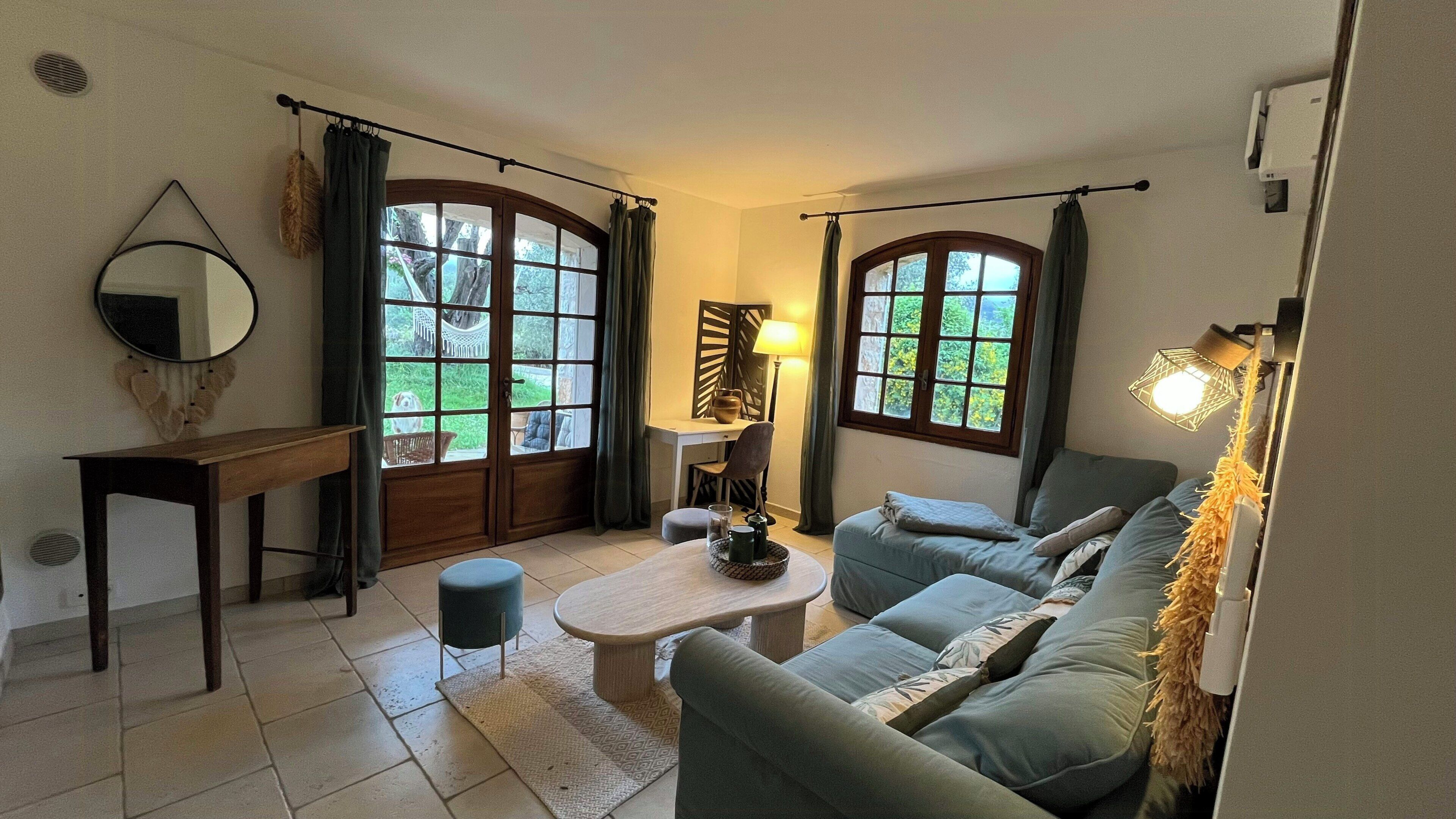 A living room with a sofa, a coffee table, a desk, and a lamp.