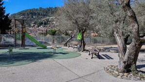 A playground with a slide, benches, and a tree. - Quiet Detached Chalet for Five (Sollies-Toucas)