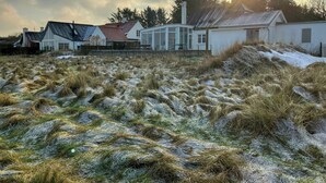 A house with a sloped roof, a conservatory, and a white exterior. - Restored fisherman's house on cliff in Thy (Hanstholm)