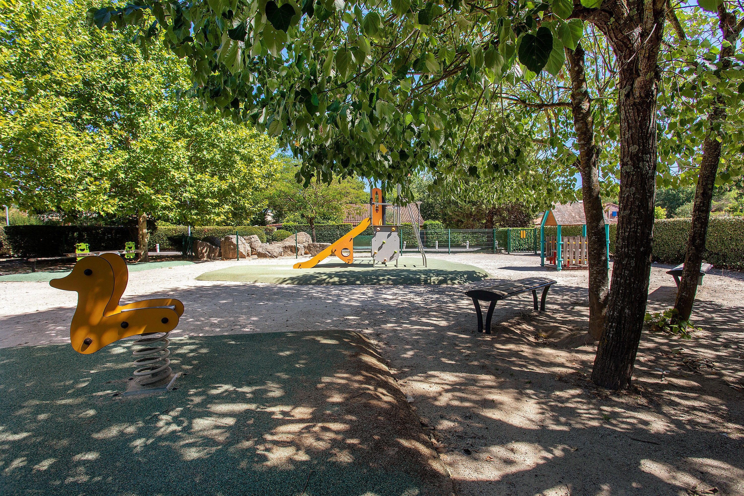 Un parque infantil con tobogán, columpios y estructura para escalar.