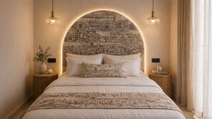 A bedroom with a large bed, two bedside tables, a circular wall arch, and pendant lights. - Koryfo Old Town Stay by Corfuescapes (Kerkira)