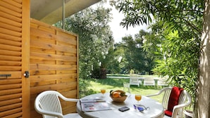 A wooden wall, a round table with chairs, a basket of fruit, and a glass of orange juice. - Holiday Home Near Lake Saint-cassien (Tourrettes)