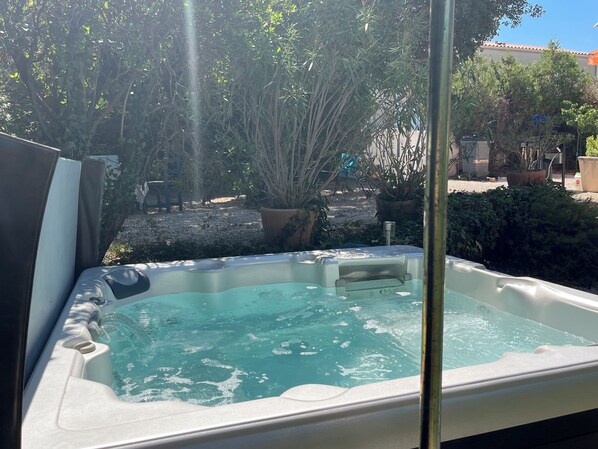 A hot tub with a view of a garden and a building in the background. - Villa Lou Gaiardoun in the center of St Aygulf sea & shops on foot🌴☀️ (Fréjus)