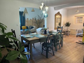 A dining area with a wooden table set for four, surrounded by chairs. - Villa Lou Gaiardoun in the center of St Aygulf sea & shops on foot🌴☀️ (Fréjus)
