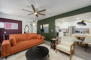 A modern living room with a sofa, a coffee table, and a dining area with chairs and a table. - 2 Mins to ASU, Swimming Pool, King Bed (Tempe)