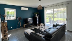 A modern living room with a sectional sofa, a TV, a lamp, and a large window. - 🌿Very luminous villa near Uzès - peace & quiet 🌿 (Cavillargues)