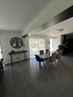 A modern kitchen with a dining area, a large window, and a wall-mounted tree decoration. - 🌿Very luminous villa near Uzès - peace & quiet 🌿 (Cavillargues)